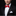 Man wearing a black tuxedo with a red bow tie on a black background