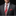 Man wearing a gray suit with a red paisley tie and pocket square on a black background