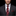 Man wearing a dark suit with a red patterned tie and pocket square on a black background