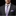 Man wearing a dark suit with a purple and gray striped tie and matching pocket square on a black background