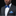 Man wearing a gray suit with a blue bow tie and pocket square on a black background