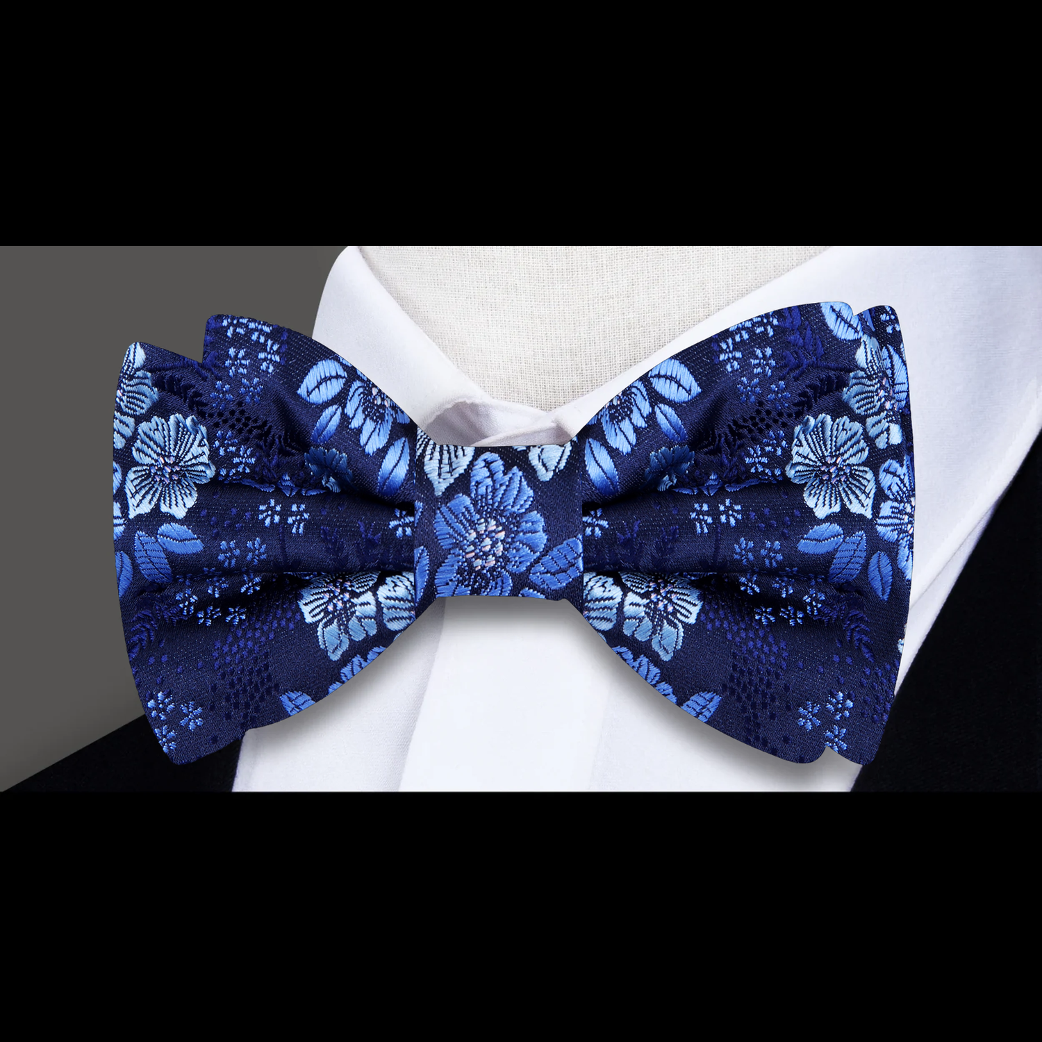 Blue floral bow tie on a white shirt against a dark background