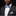 Man wearing a black suit with a colorful bow tie and matching pocket square on a black background
