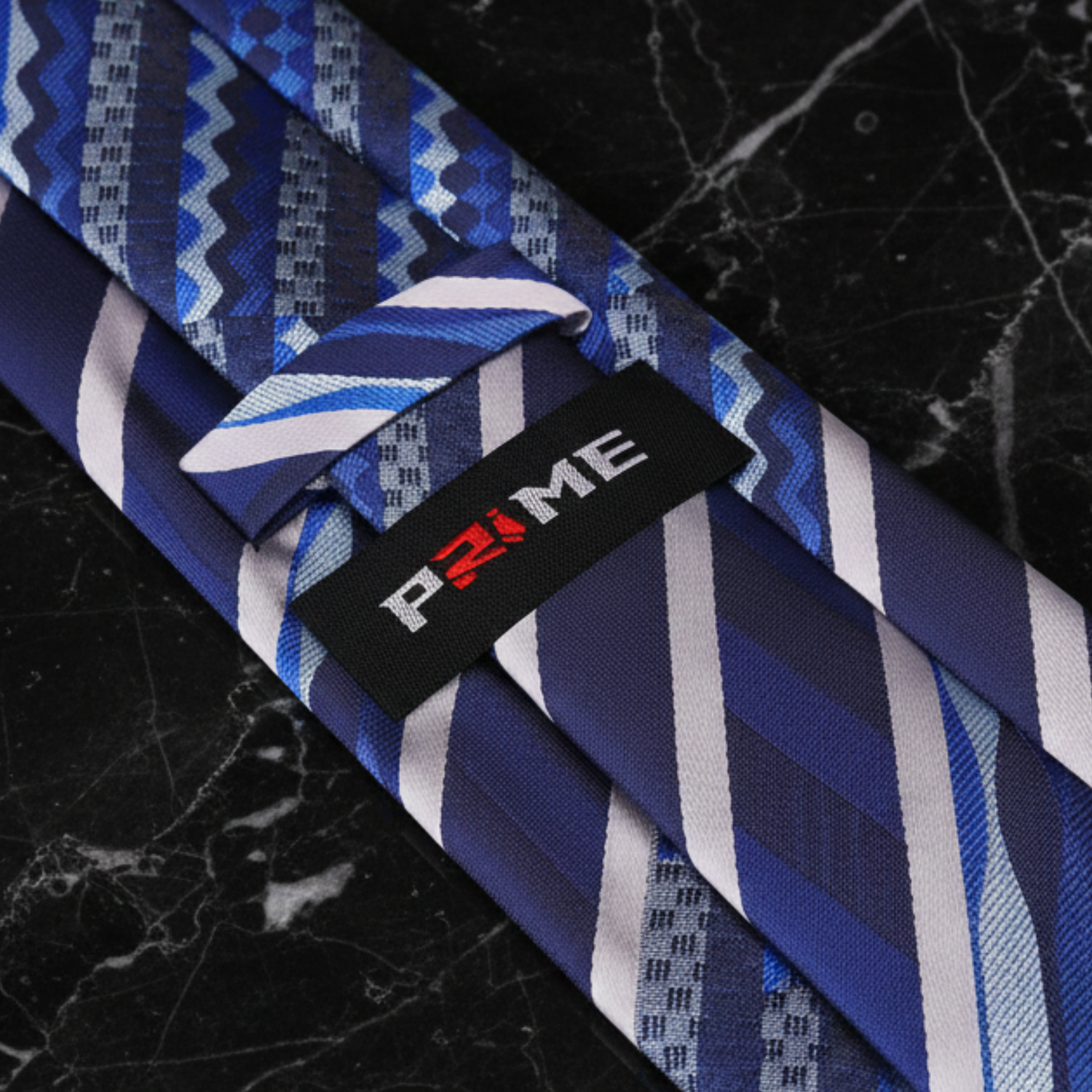 Blue and white patterned tie with a visible brand label on a white background