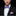 Man wearing a black suit with a purple and blue zigzag bow tie and matching pocket square.