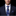 Man wearing a navy suit with a blue paisley tie and pocket square on a black background