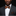 Man wearing a black suit with a patterned bow tie and pocket square on a black background