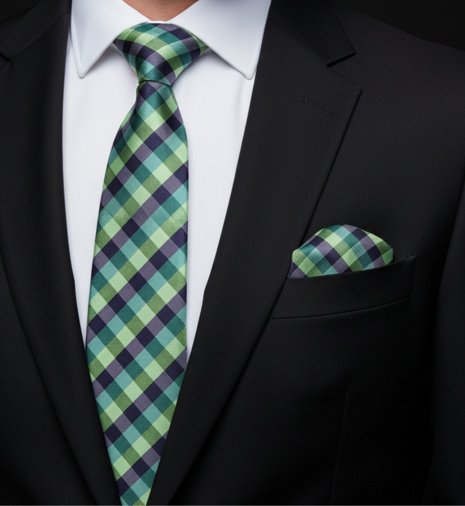 Green and purple checkered tie and pocket square on a black suit.