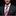 Man wearing a black suit with a pink and purple striped tie and matching pocket square on a black background