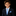 Young boy in a dark suit with a blue tie and pocket square on a black background