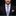 Man wearing a black suit with a colorful tie and pocket square on a black background