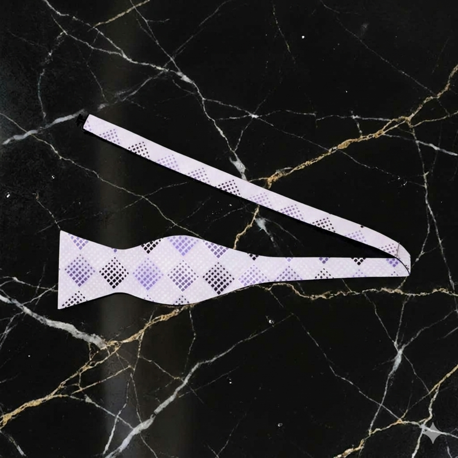 White bow tie with purple pattern on a black marble background