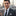 Man in a suit and black paisley square with a cityscape in the background