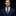 Man wearing a navy suit with a patterned tie against a dark background