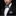 Man wearing a black tuxedo with a striped bow tie and pocket square on a black background