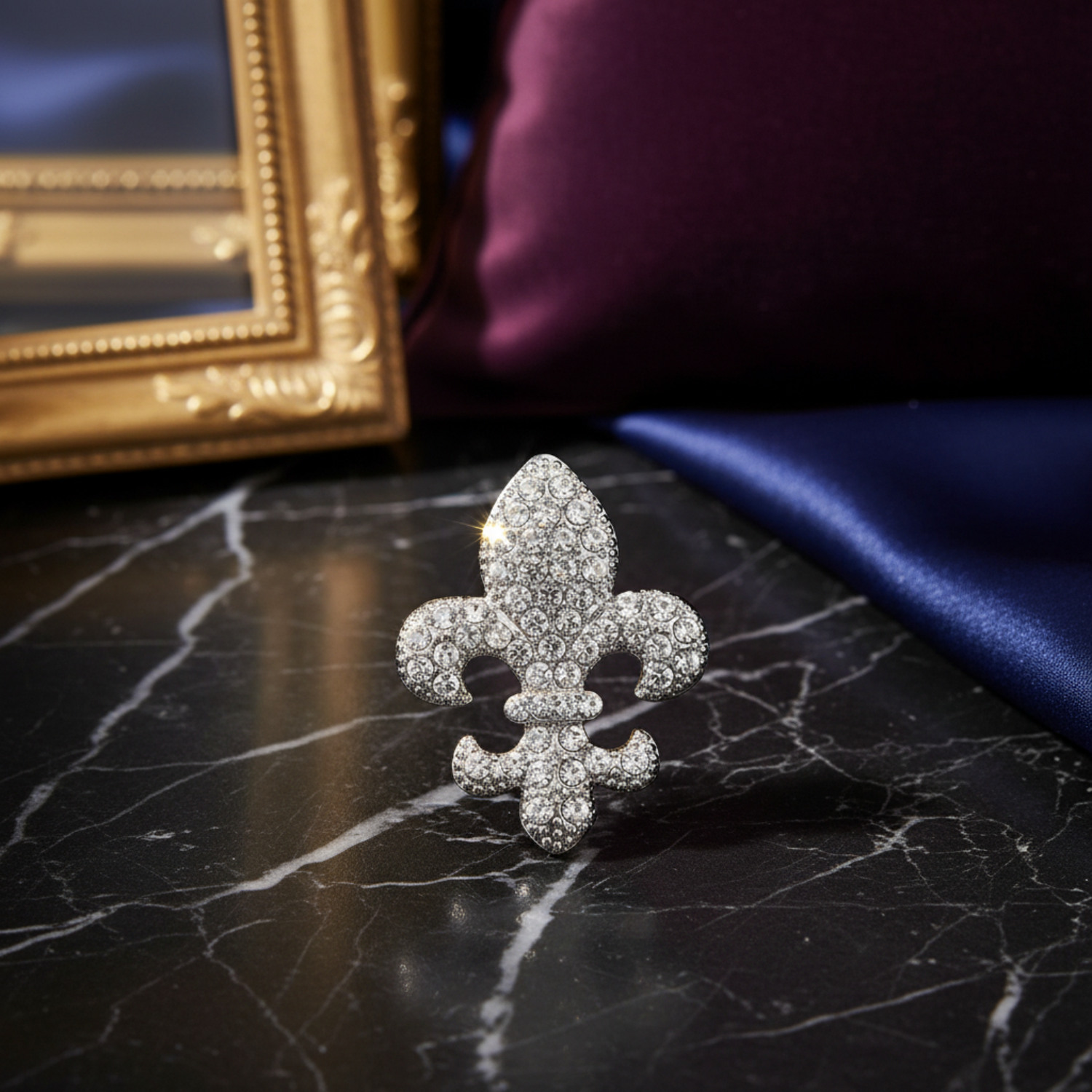 Silver fleur-de-lis brooch with clear gemstones on a white background