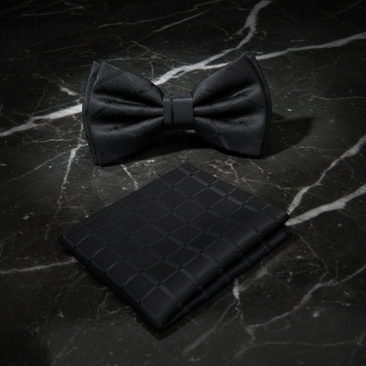 Black bow tie and matching pocket square on a white background