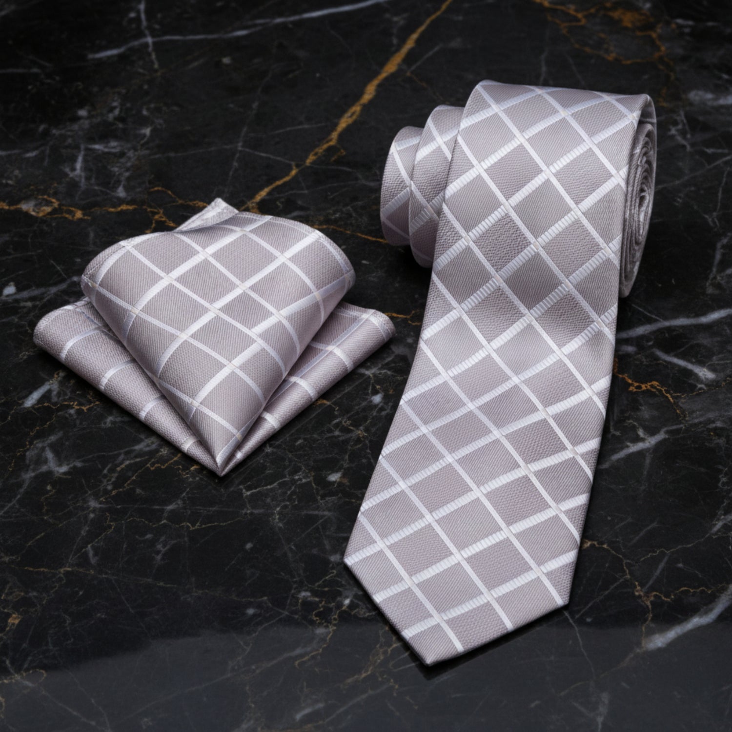 Gray tie and pocket square set with white grid pattern on a white background