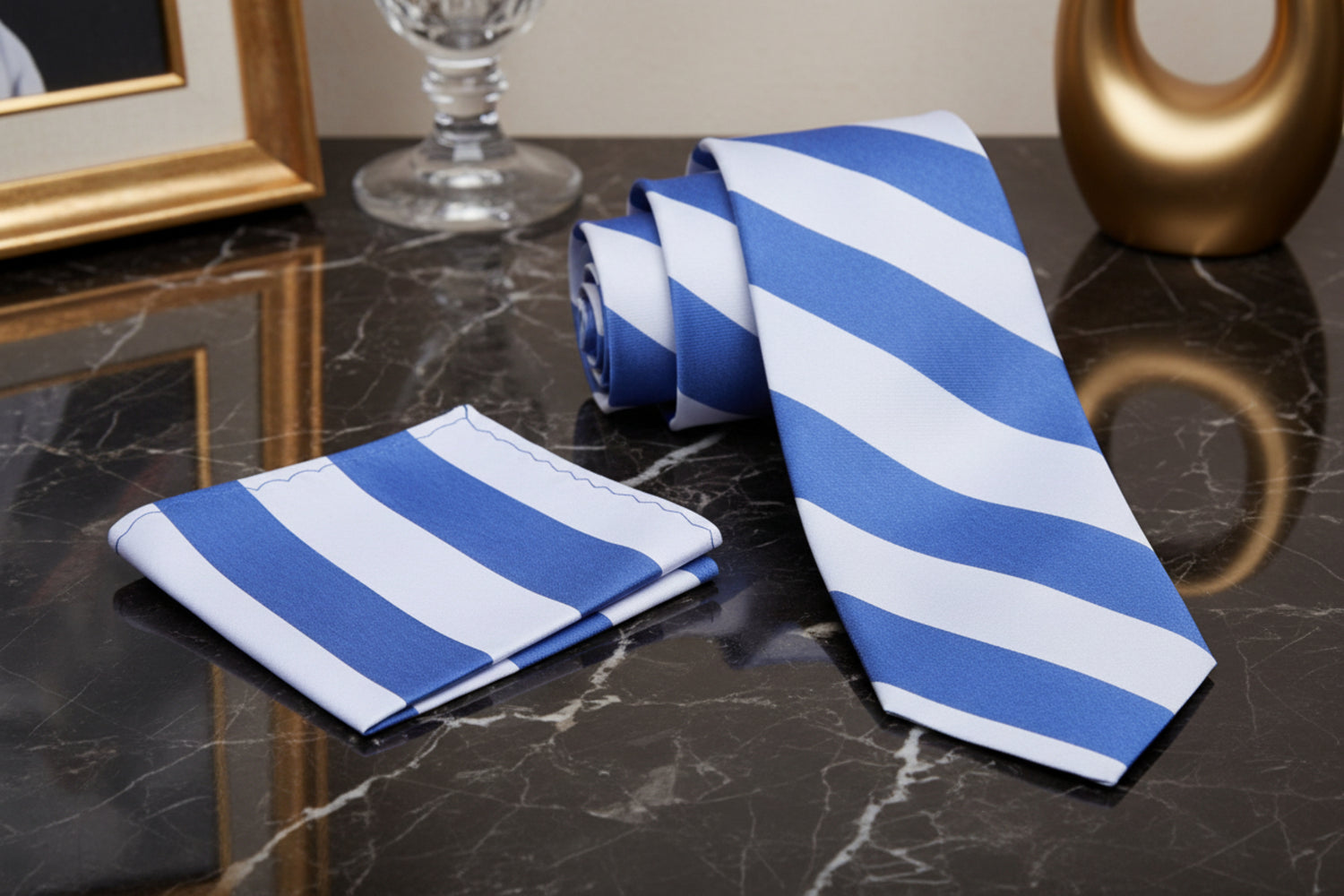 Blue and white striped tie and pocket square on a marble surface