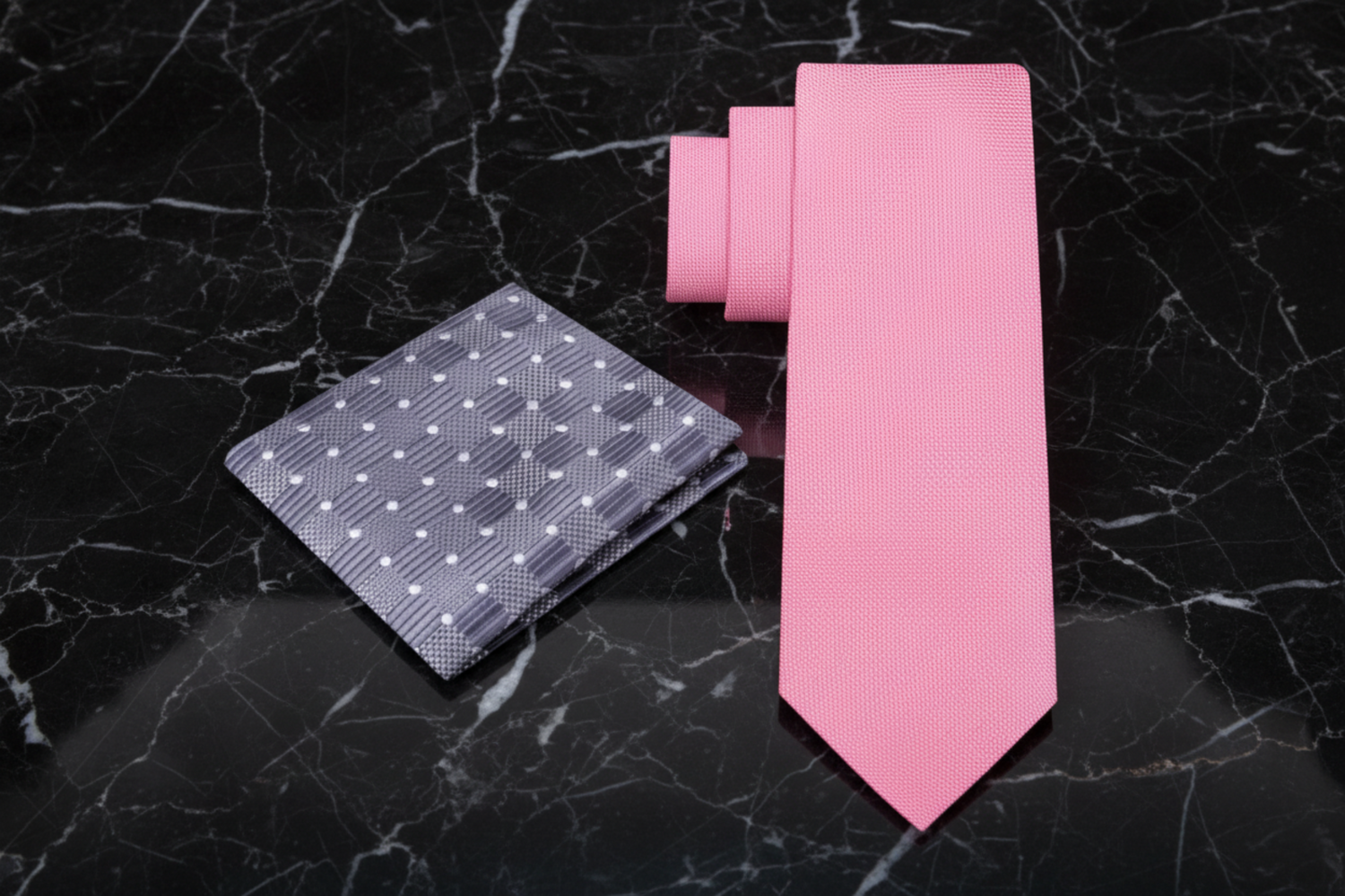 Pink tie and patterned pocket square on a marble background