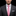 Man wearing a dark suit with a pink tie on a black background