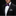 Man wearing a black tuxedo with a purple bow tie and white shirt against a black background