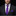 Man wearing a black suit with a purple tie and pocket square on a dark background