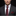Man wearing a dark suit with a white shirt and red tie against a black background