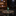 A miniature green Statue of Liberty figurine holding a golden torch, standing on a small beige base