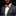 Man wearing a gray suit with an orange bow tie and plaid pocket square on a black background