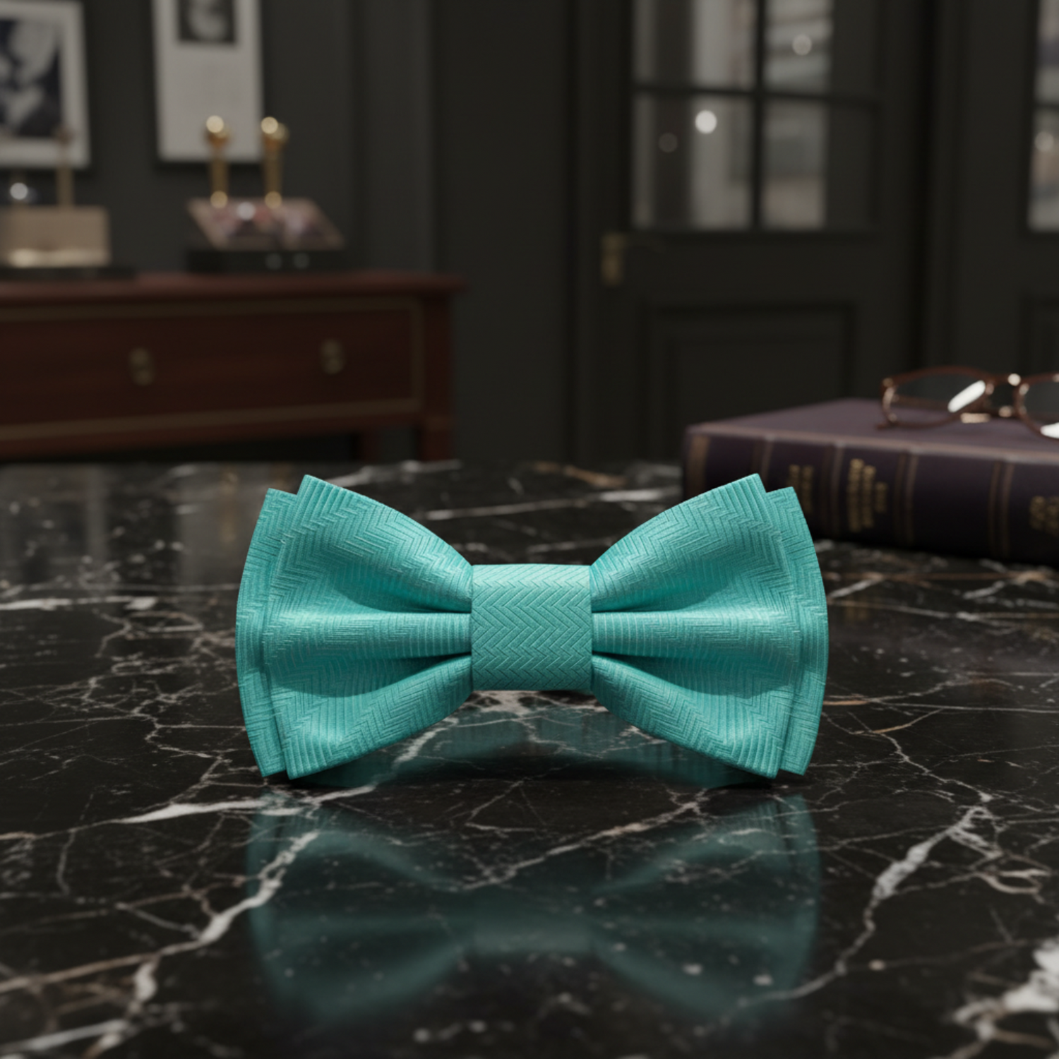 Turquoise bow tie on a dark marble surface with ornate gold frames in the background