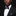 Man wearing a black suit with a purple bow tie and pocket square against a dark background