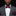 Man wearing a gray suit with a red bow tie and pocket square on a black background