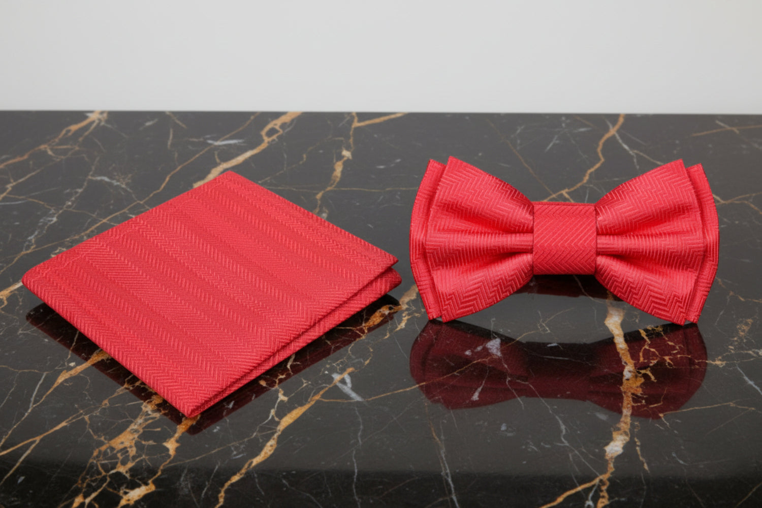 Red bow tie and matching pocket square on a white background