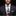 Man wearing a black suit with a patterned tie and pocket square against a dark background