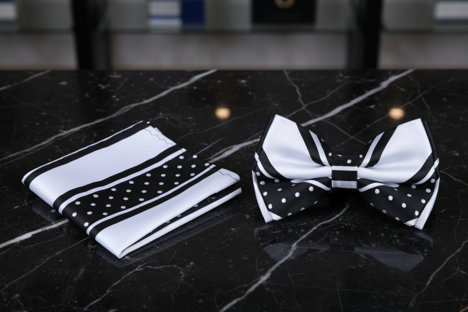 A matching men's accessory set featuring a black and white striped and polka-dot necktie and a matching pocket square, displayed on a clean white background.