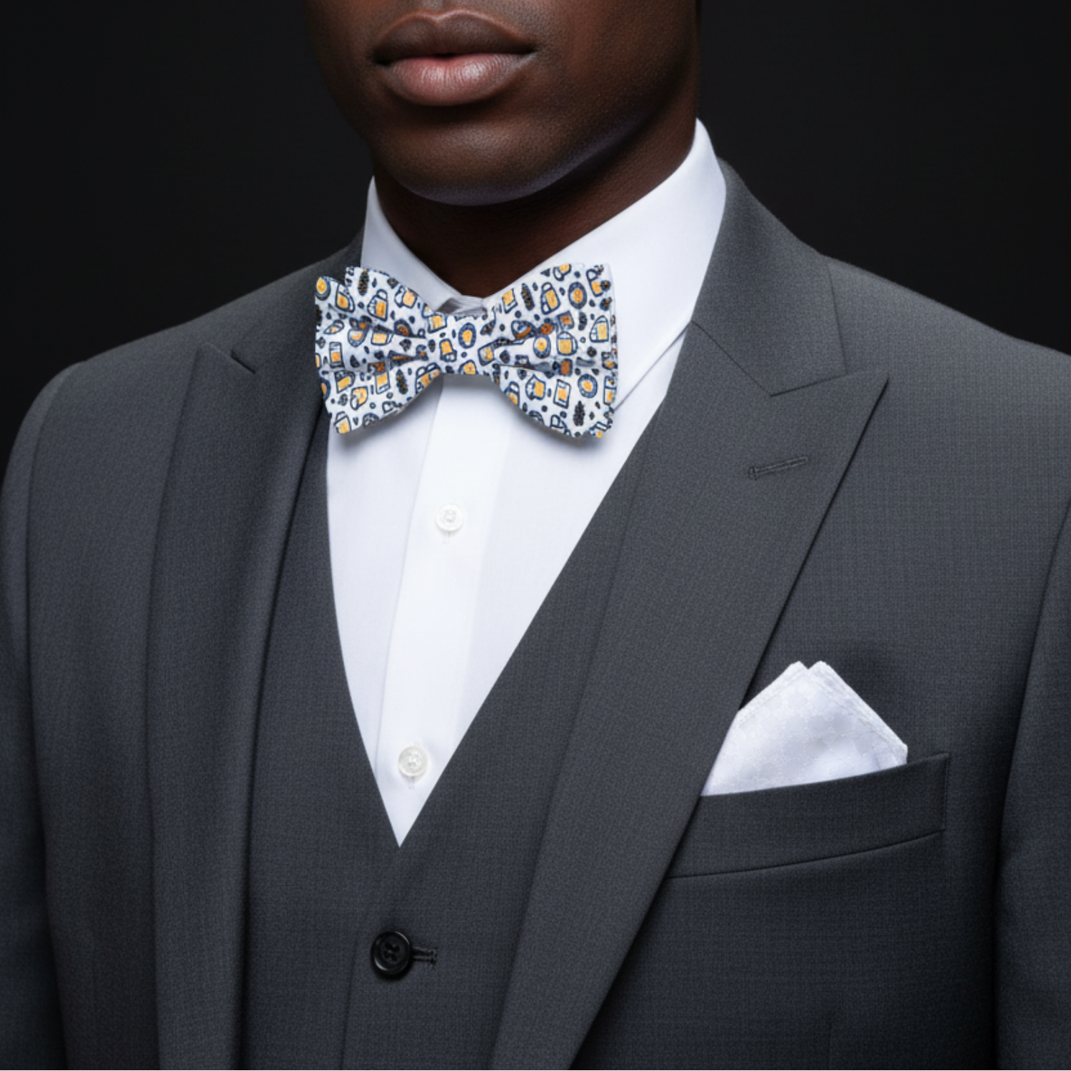 Man wearing a gray suit with a patterned bow tie against a black background