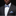 Man wearing a dark suit with a white shirt, blue polka dot bow tie, and matching pocket square against a black background.