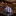 Plaid tie on a reflective surface with a background of shelves containing more ties.