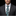 Man wearing a dark suit and patterned tie against a black background