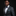 Man wearing a gray suit with a colorful bow tie and pocket square on a black background
