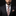 Man wearing a dark suit with a checkered tie and pocket square on a black background