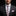 Man wearing a dark suit with a colorful striped tie and pink pocket square on a black background