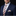 Man wearing a navy suit with a colorful striped tie and pocket square on a black background