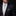 Man wearing a black suit with a patterned tie and green pocket square on a dark background