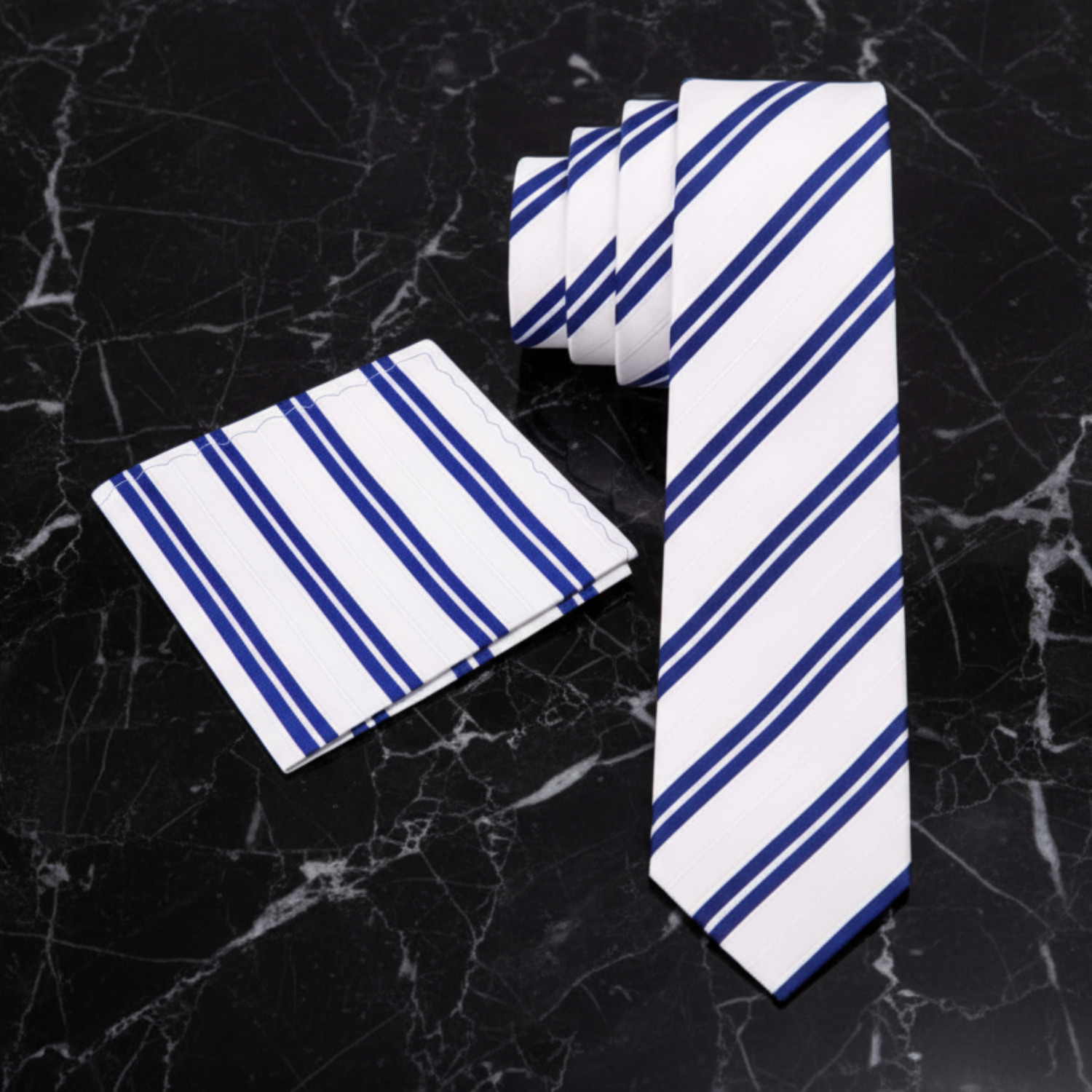 White tie with blue stripes and matching pocket square on a black marble background