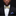 Man wearing a black suit with a white shirt and decorative bow tie against a dark background