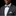 Man wearing a gray suit with a colorful bow tie and pocket square on a black background