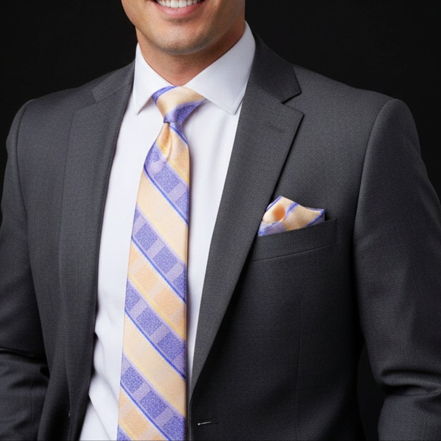Man wearing a gray suit with a colorful striped tie against a black background