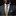 Man wearing a gray suit with a colorful tie and pocket square against a black background